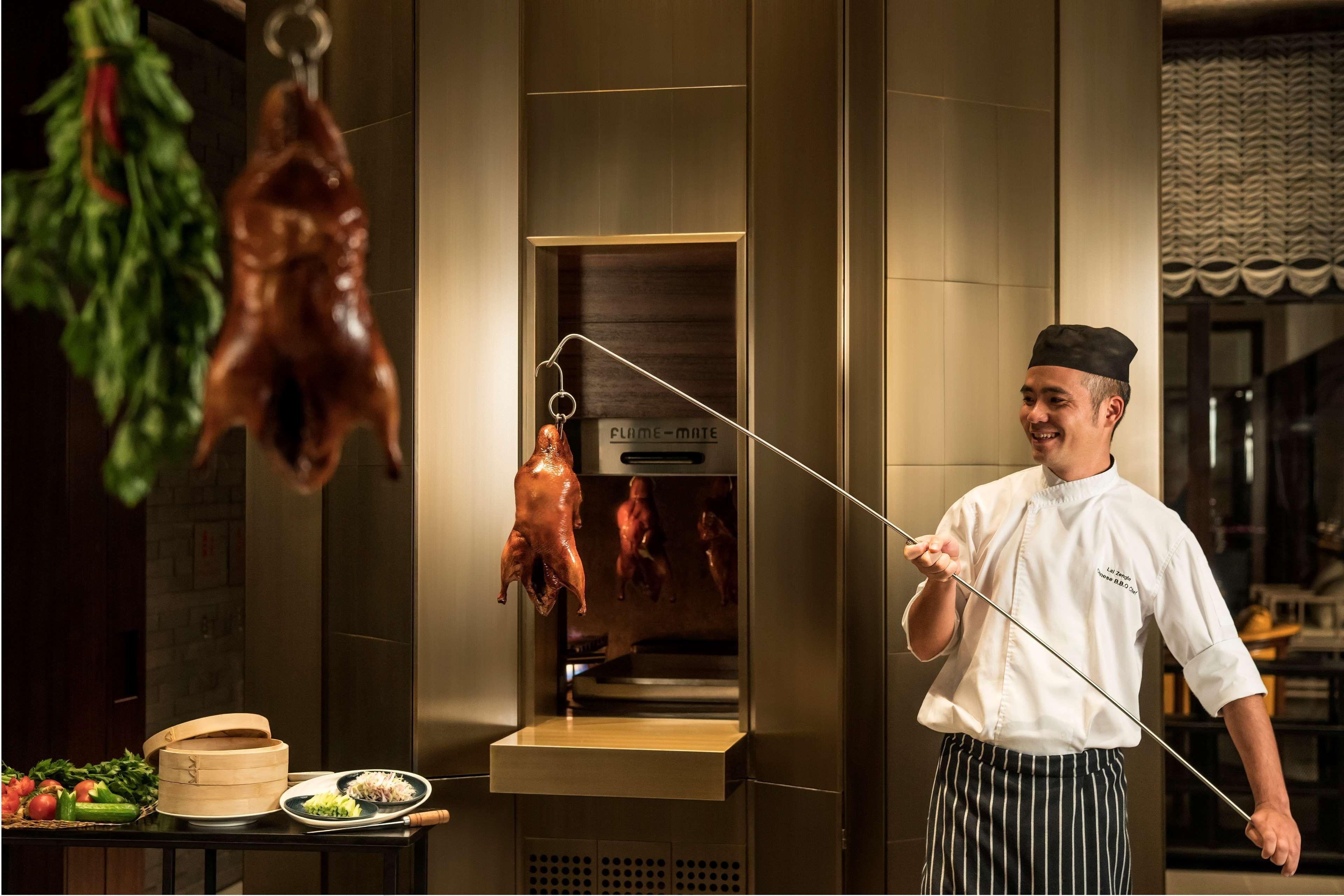 Shangri-La 콜롬보 외부 사진 Chef pulling a duck out of a hanging oven